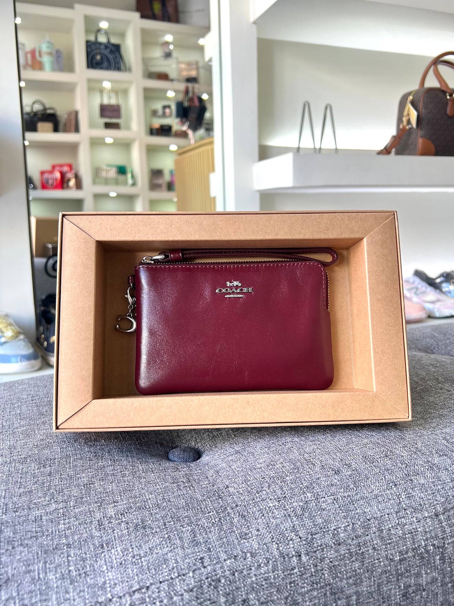 Cartera Coach tinta con llavero de arcoíris y letra C